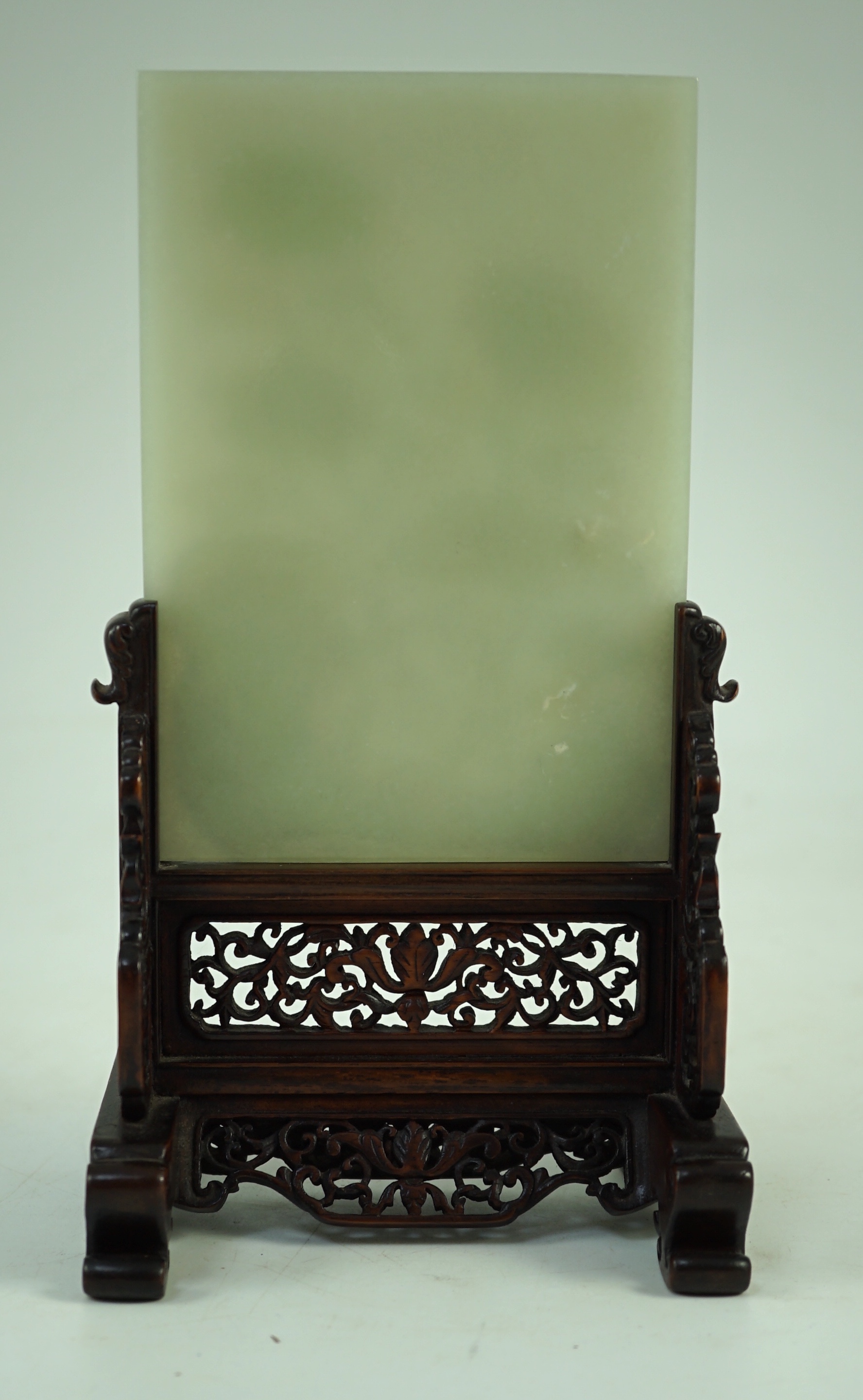 A good Chinese celadon jade ‘peonies and rockwork’ small table screen and stand, 18th/19th century, Jade 14.7 cm x 10.3cm, total size including carved wood stand 22cm x 12.3cm